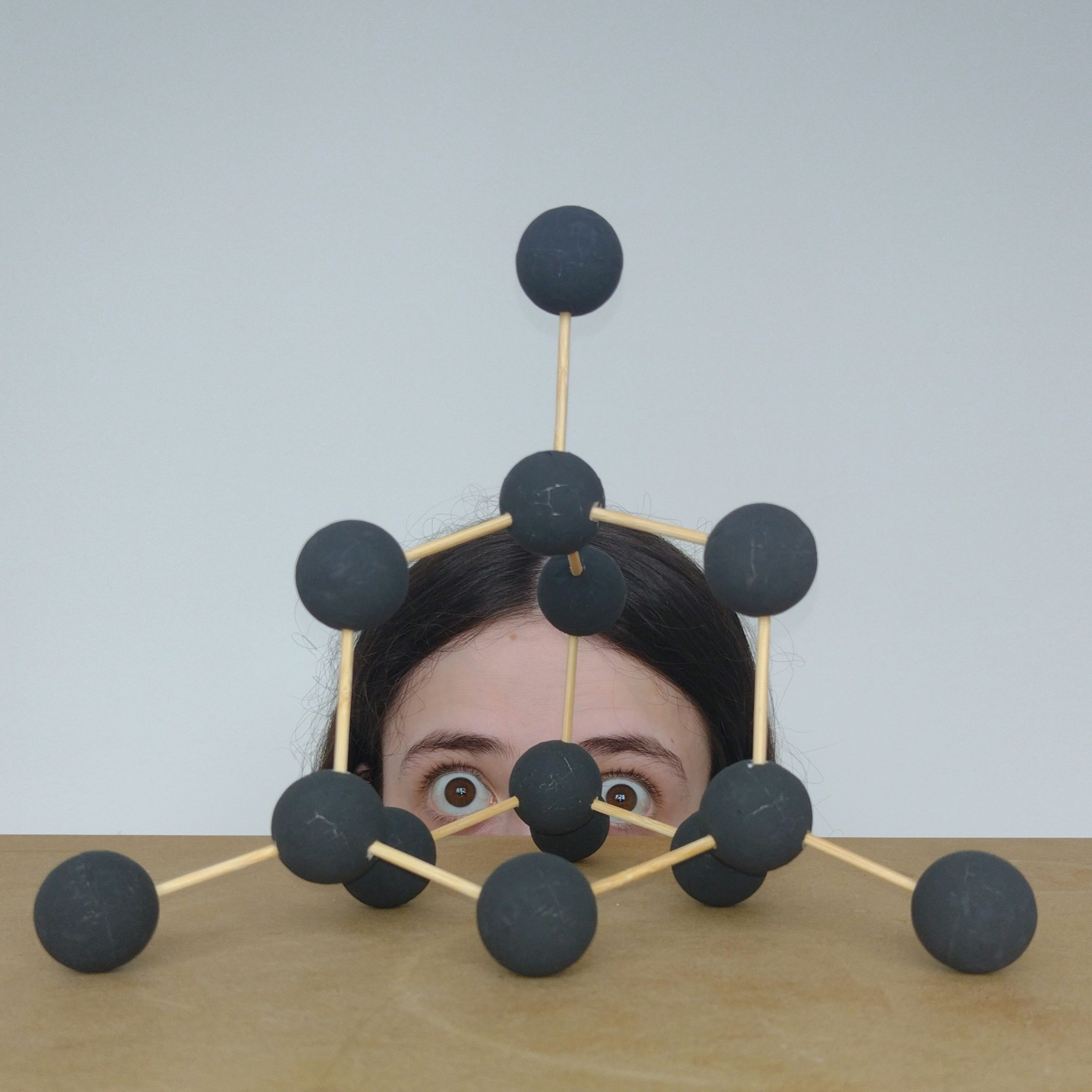 A picture of me behind a model of a ball-and-stick model of a diamond crystal.